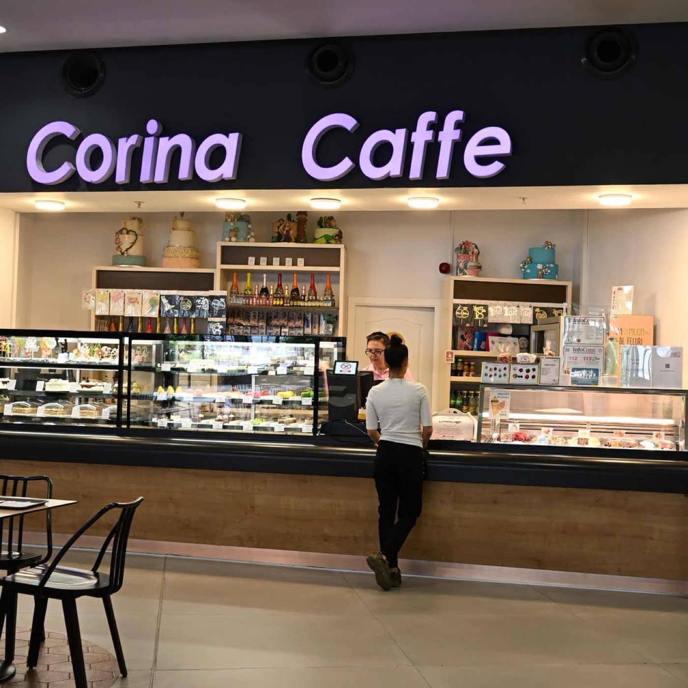 Interiorul cofetăriei Corina Caffe, cu tejgheaua și firma luminoasă