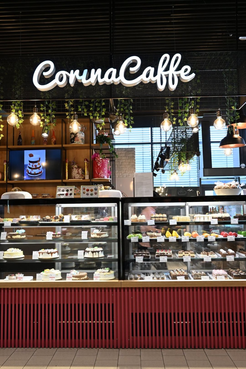 Vitrina Corina Caffe seara, cu firma luminoasă și soclul bordo cu lamele